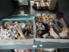 A shelf of modern reproduction ceramic dolls along with similar accessories all for Dolls Houses