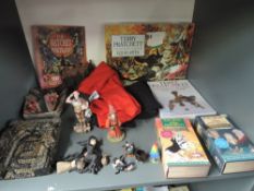 A shelf of Terry Pratchett Volumes, similar figures, Video's and T-Shirts including Unseen