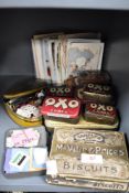 A selection of early 20th century advertising tins and postcards