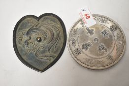 An 18th century Chinese bronze mirror having Phoenix decoration in a heart shaped design with a