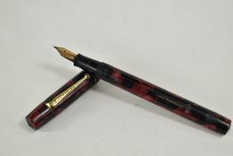 An Ingersoll lever fill fountain pen in red black marble with single narrow band to cap having