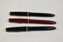 Three Parker Slimfold aeromatic fill fountain pens two in black one red, having decorative band to