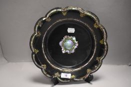 A Victorian papier mache shallow bowl having mother of pearl inlay decoration and scalloped rim.