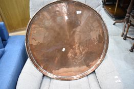 A large copper tray of circular form having pie crust edge, diameter approx. 65cm