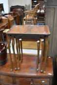 A reproduction walnut nest of three tables