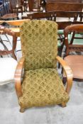 An early 20th Century oak framed easy chair of stylised design