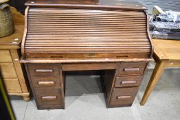 An early 20th Century oak roll top desk