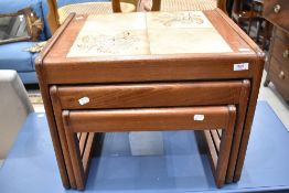 A vintage teak and tile top nest of three tables