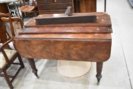 An early 19th Century mahogany extending dining table having fluted legs and additional leaves