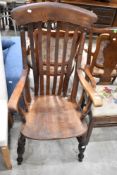 A 19th Century stained frame kitchen armchair having H stretcher