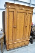A modern pine wardrobe having drawer base, width approx. 129cm