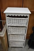 A modern painted storage unit having wicker drawers
