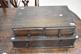 A dark stained set of artists or engineers desk top drawers