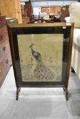 A traditional embroidered firescreen , peacock design