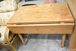 A natural pine drop leaf dining table, width approx. 107cm