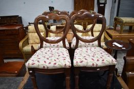 A set of four Victorian mahogany dining chairs having shaped balloon backs, turned legs and later