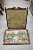 A mahogany fire screen and oak tray with Helen Bradley type themed woolwork panel