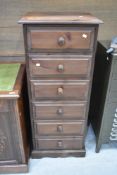 A modern pine narrow chest of six drawers in dark stain, height approx. 124cm