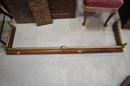 A traditional wood and brass fire fender, internal dimensions approx. 139cm x 36cm