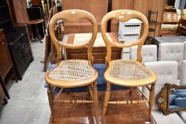 A pair of Victorian cane seated bedroom chairs and a stained frame baloon back chair