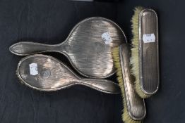 A four piece silver dressing table set having engine turned stripe decoration and bearing initial '