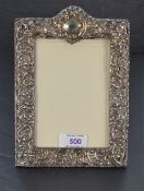 An Victorian silver photograph frame having extensive cut decoration, plain cartouche and blue