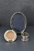 An modern oval silver photograph with black velvet easel back, a small circular silver photo frame