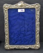 An Edwardian silver photograph frame having extensive cut decoration, plain cartouche and purple