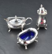 A silver three piece cruet set of traditional form having blue glass liners and paw feet, Birmingham