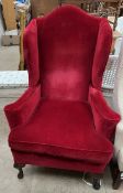 An early 20th century wing back armchair on cabriole legs and pad feet
