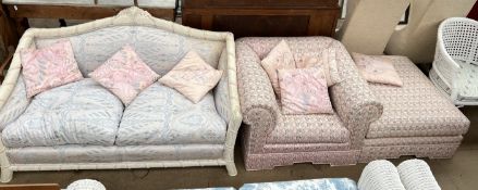 A carved cream two seater settee together with an upholstered arm chair and a footstool