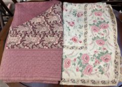 A floral decorated quilt together with another floral decorated quilt