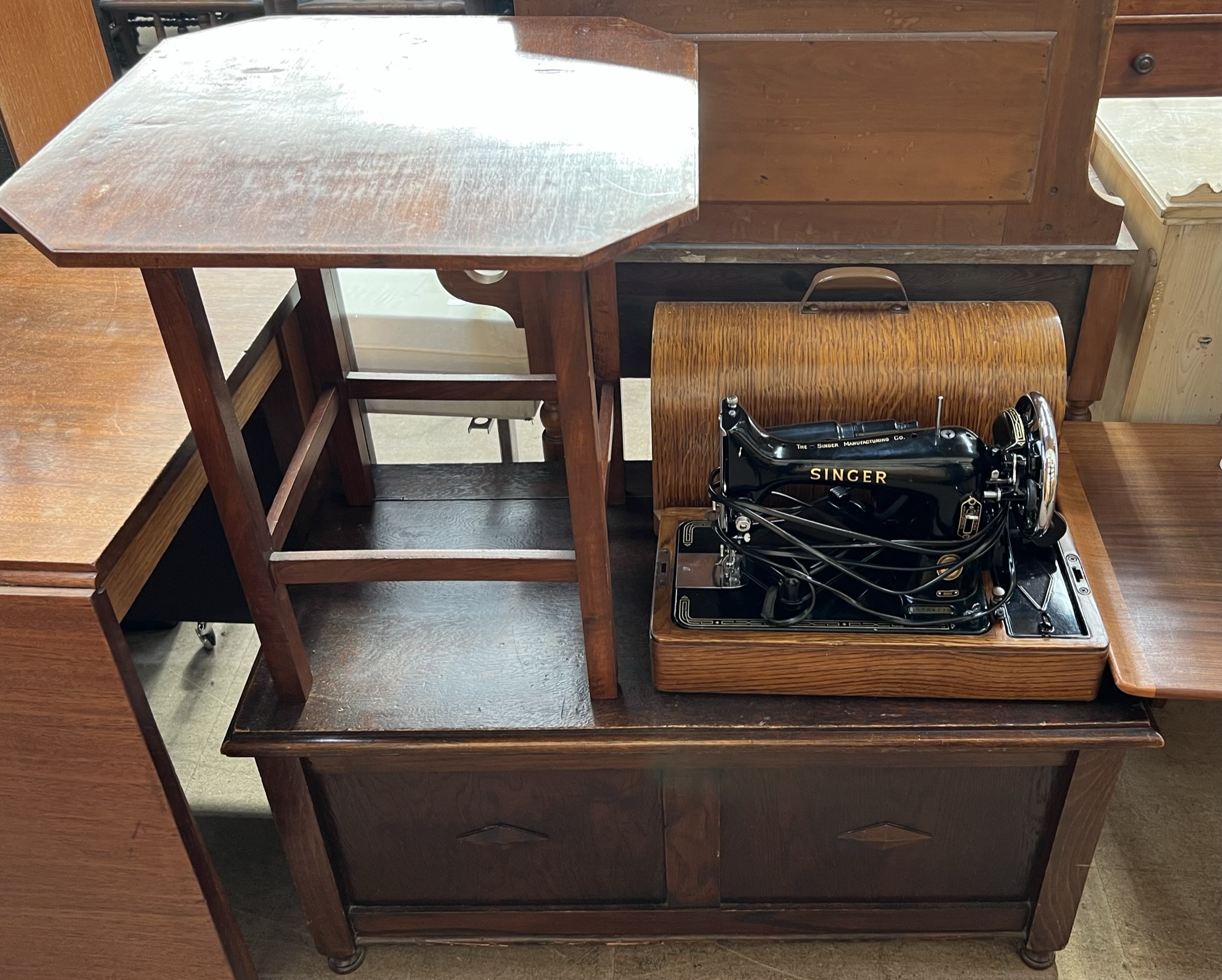 An oak coffer with a rectangular top above a two panel front on turned legs together with an