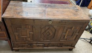 An 18th century carved oak coffer, the rectangular planked top above a three panel front,