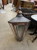 A large copper wall mounted lantern with a turned finial and panelled hexagonal top and tapering