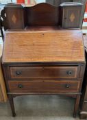 An Edwardian mahogany bureau with a raised superstructure and cupboards above a sloping fall