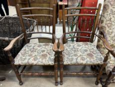 A pair of spindle back elbow chairs with pad upholstered seats on turned legs united by stretchers