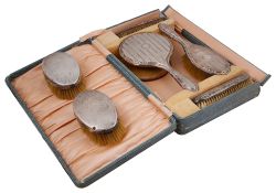 A George V cased four piece silver backed dressing table set and a pair of clothes brushes