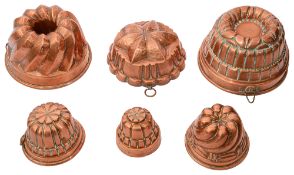 A collection of six copper jelly moulds