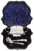 An Edwardian cased silver twin handled sugar bowl, sifter spoon and sugar tongs