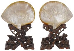 A late 19th century pair of Chinese Canton carved mother of pearl shells on hard wood stands