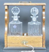 EARLY 20TH CENTURY OAK & BRASS TWO DECANTER TANTALUS
