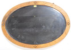 A large early 20th century Arts & Crafts oval wall mirror in the manner of Newlyn