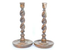 A PAIR OF OAK BARLEY TWIST CANDLESTICK HOLDERS