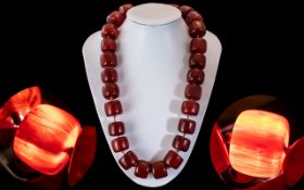A Faux Cherry Amber Barrel Bead Necklace, each bead individually knotted. Length 60 cm.