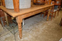 A pine kitchen table with turned legs.