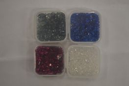 Four small boxes of coloured spinels.