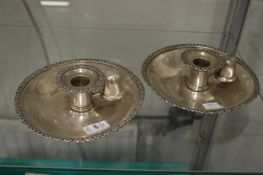 An unusual pair of plated chamber sticks engraved with a crest.