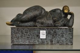 In the manner of Barbara Hepworth, a small bronze reclining female nude on a rectangular base.