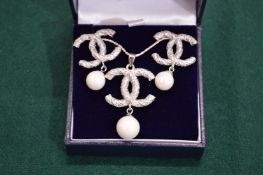 A decorative necklace, pendant and earring set.